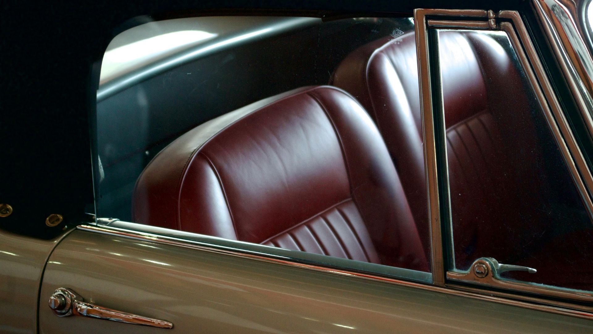 Vintage car interior with rich burgundy leather seats and chrome details