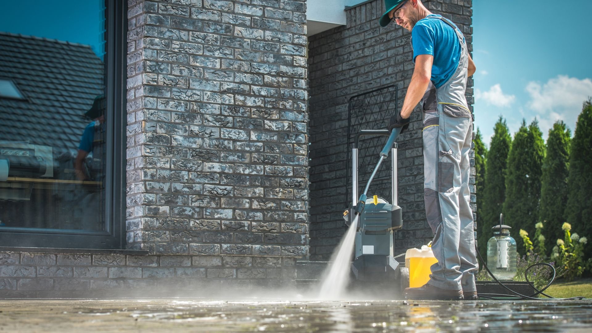 Professional cleaning concrete surface with high-pressure water washer